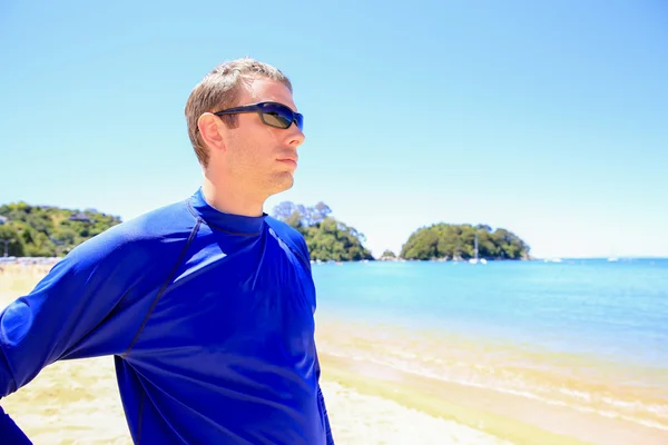 Young man in blue shirt enjoying Beautiful orange beaches — Stock Photo, Image