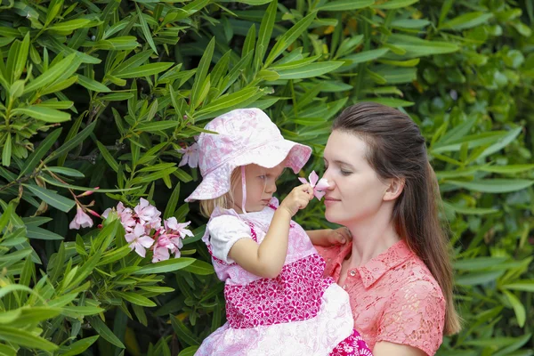 Söt dotter och lycklig mamma att lukta blommor utomhus — Stockfoto