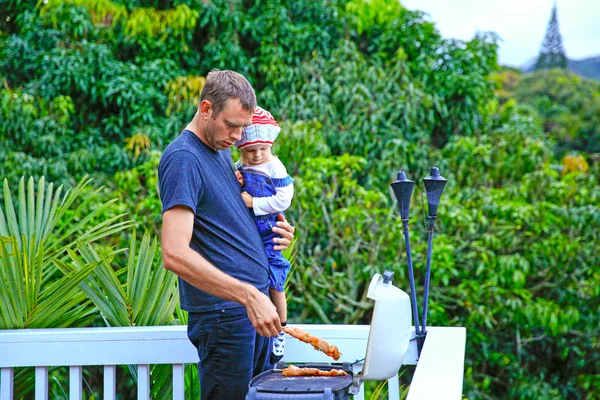 Young loving father and his cute daughter grilling meat — Stock Photo, Image