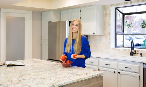 Attractive young blond-haired woman  in the kitchen — Stock Photo, Image