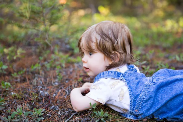 Adorable niña pequeña acostada en el suelo con la cara hacia arriba —  Fotos de Stock