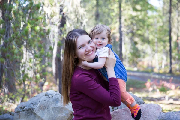 Felice giovane madre con la sua bambina nella foresta di montagna — Foto Stock