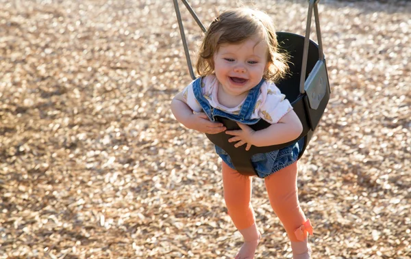 Niedliches Baby Mädchen hat Spaß auf einer Schaukel — Stockfoto