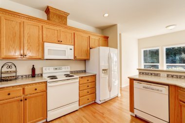 Açık kahverengi mutfak dolapları ve beyaz eşya