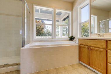 Ahşap dolaplar ve beyaz küvet ile lüks banyo iç