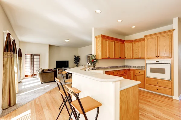 Light brown kitchen cabinets and bar counter with stools — Stock Photo, Image