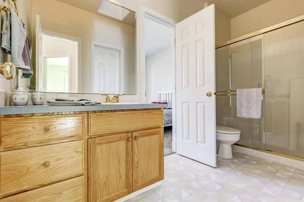 Wooden vanity cabinet, glass shower and a toilet — ストック写真