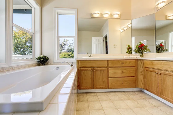 Interior de baño de lujo con armarios de madera y bañera blanca — Foto de Stock