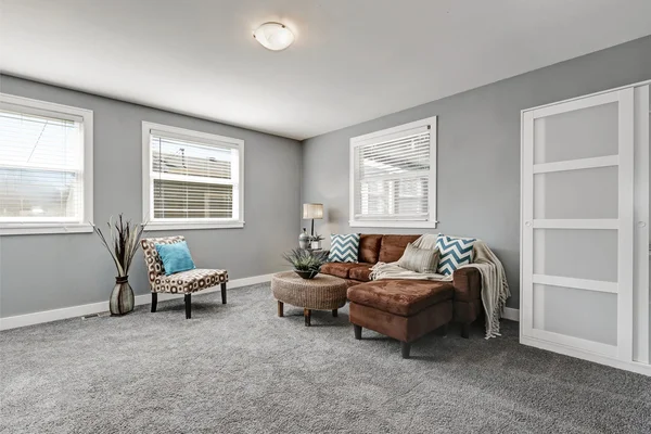 Tons de cinza área de estar com sofá marrom confortável — Fotografia de Stock