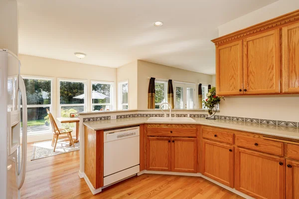 Light brown kitchen cabinets and white appliances Stock Image