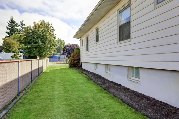 Huis exterieur. Zicht op zijwand en groen gras. — Stockfoto