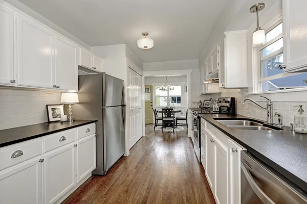 White kitchen storage combination and steel appliances — Stock Photo, Image