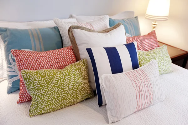 Yatak odasında özenle düzenlenmiş renkli yastıklar, yakın çekim — Stok fotoğraf