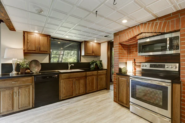 Kitchen area with red brick wall and built in appliances