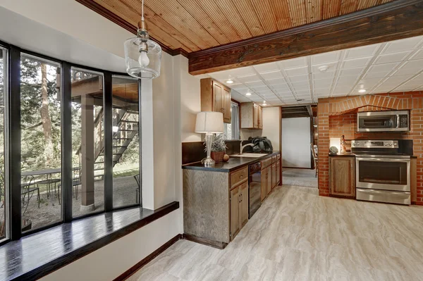 Kitchen area with red brick wall and built in appliances