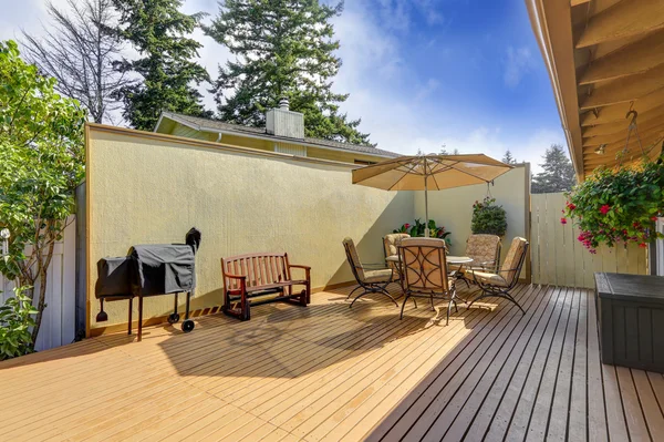 Patio-Tisch mit geöffnetem Sonnenschirm. Holzsteg — Stockfoto