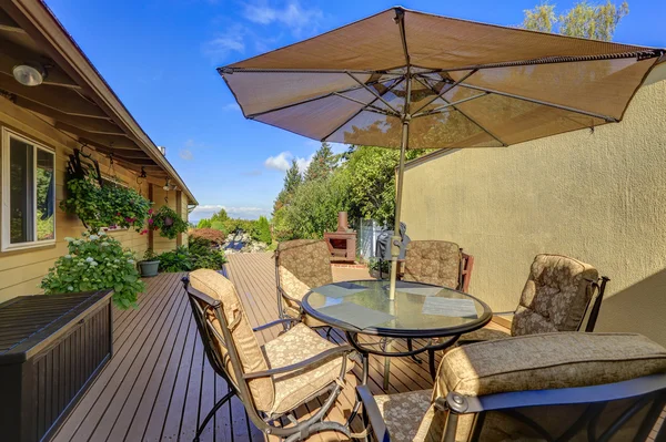 Patio-Tisch mit geöffnetem Sonnenschirm. Holzsteg — Stockfoto