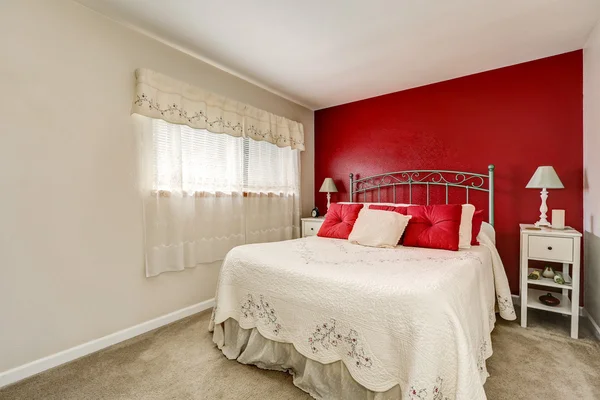Ložnice bystré ženy s červenou kontrastní stěnou — Stock fotografie