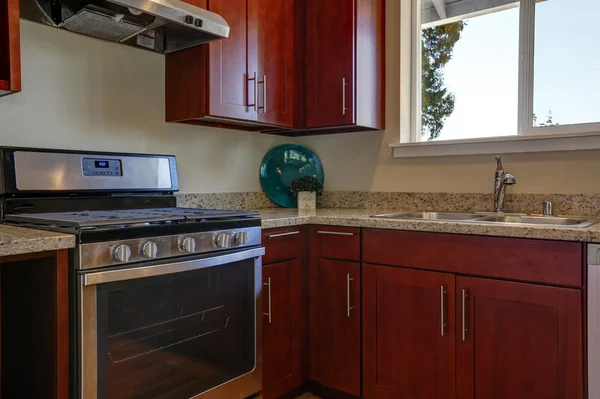 View of burgundy kitchen cabinets with granite counter top — Stock fotografie