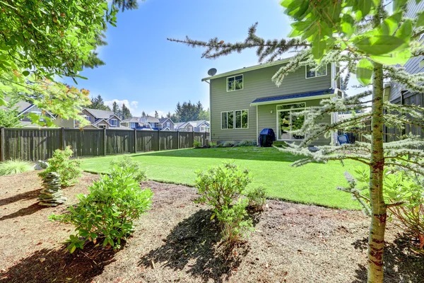 Backyard area of American gray house with well kept lawn — Φωτογραφία Αρχείου