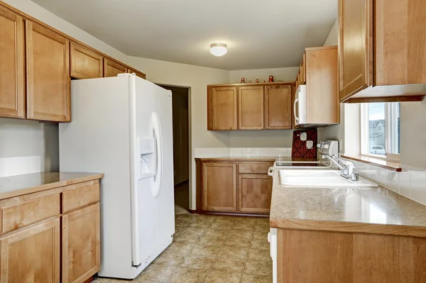 Wooden kitchen storage combination and white fridge — ストック写真