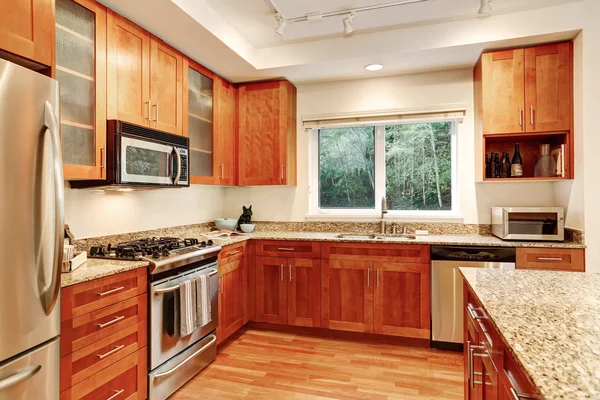 Interior de la cocina. Gabinetes de madera, encimeras de granito y vista a la ventana —  Fotos de Stock