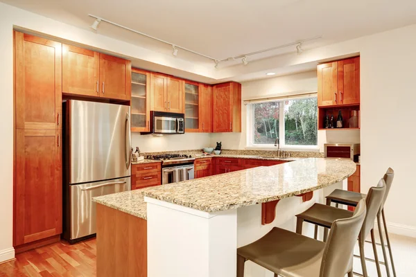 Kitchen interior. Wooden cabinets, granite tops and window view — ストック写真