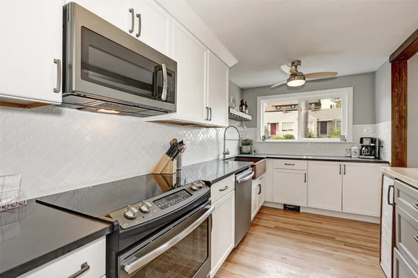 Интерьер белой кухни с серыми деталями — стоковое фото