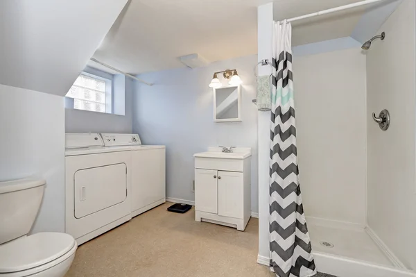 Light blue bathroom interior with laundry appliances — Stock fotografie