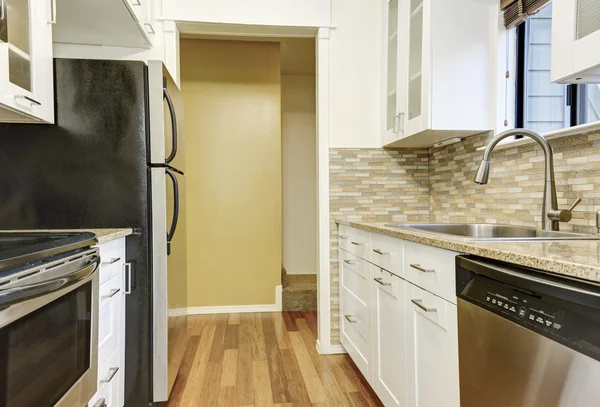 Modern fehér szekrények és barna mozaik backsplash lakásban — Stock Fotó