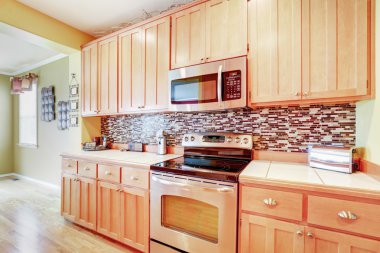 Çok renkli backsplash ile ışık ahşap dolaplar