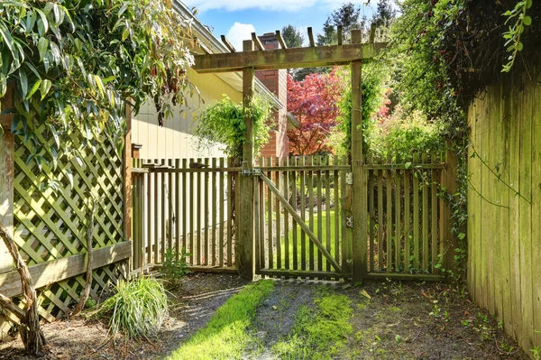 Gateway to the back yard. Rustic wooden gate and fence — Stock Photo, Image
