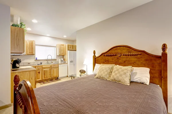 Close up of large wood carved bed and kitchen view — Stock Photo, Image