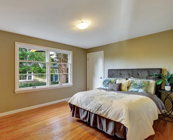 Intérieur de chambre verte avec plancher de bois franc et lit queen size . — Photo