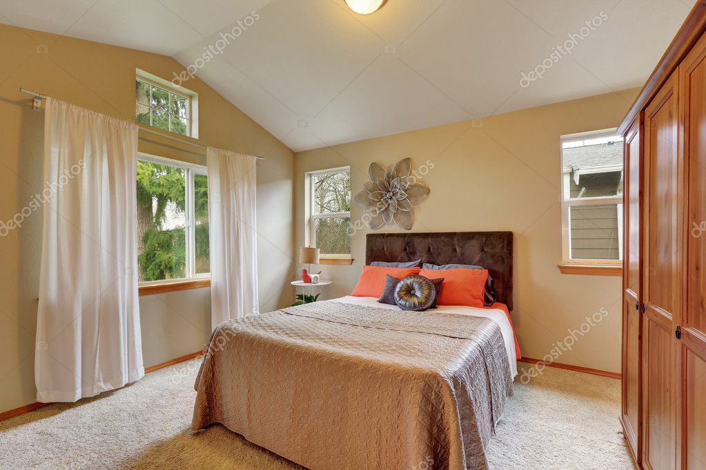 Dormitorio en la planta superior con techo abovedado y paredes beige