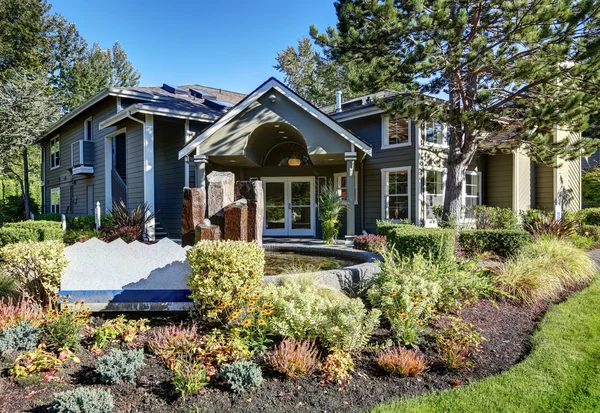 Exterior of gray house with beautiful landscape design.