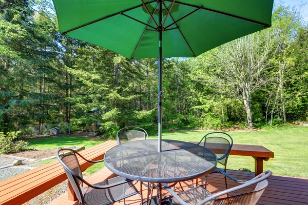 Black wrought iron patio set with open umbrella — Stock Photo, Image