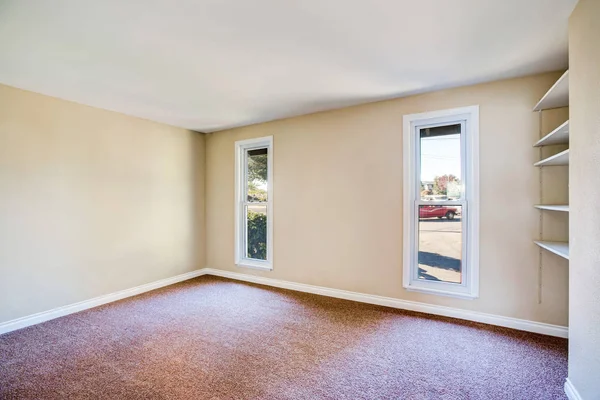 Intérieur de la chambre vide avec tapis brun et murs beige clair — Photo