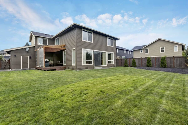 Gras gevuld achtertuin. Brown siding huis buitenkant — Stockfoto