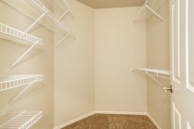 Empty walk-in closet with shelves and carpet floor clipart