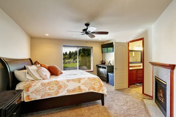 Кровать размера Queen в роскошной спальне с камином — стоковое фото