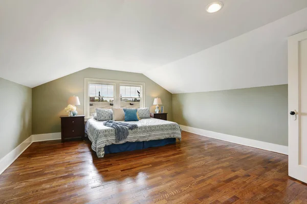 Chambre spacieuse à l'étage avec plafond voûté et plancher de bois franc — Photo