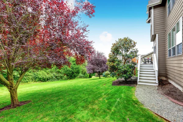 Pelouse bien entretenue dans la belle cour arrière. Maison extérieure . — Photo