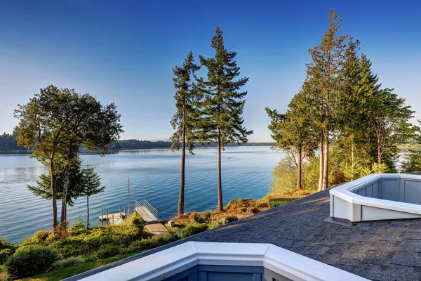 Buitenkant van het huis aan het water met een pier en de perfecte water uitzicht. — Stockfoto