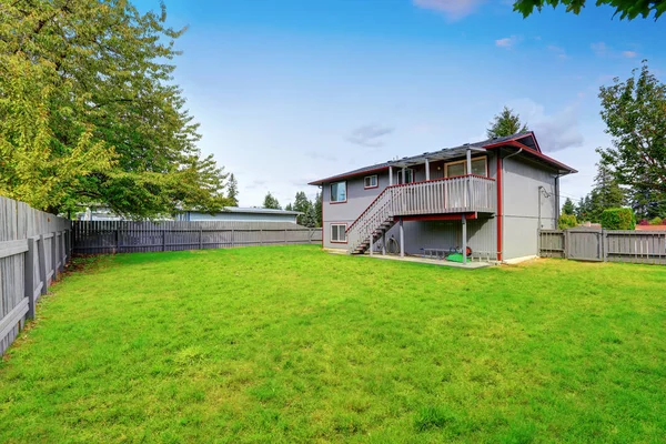 Herbe rempli arrière cour de deux étages maison grise — Photo