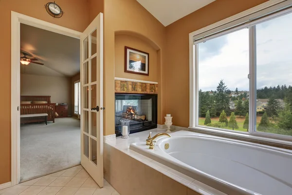 Luxury bathroom interior. Wall mounted fireplace with bath tub — Stock Photo, Image