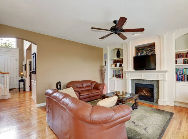 Cozy family room with brown leather sofas and fireplace — Stock Photo, Image