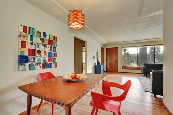 Dining area interior with red chairs and apples on the table.