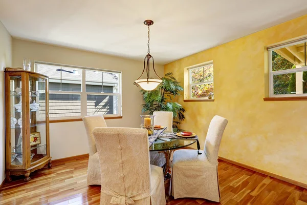 Interior da sala de jantar com parede amarela e piso em madeira . — Fotografia de Stock