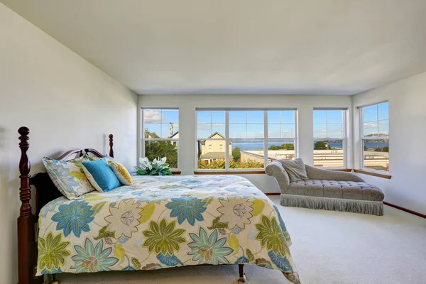 Acogedor dormitorio con cama de colores y vista al agua . — Foto de Stock